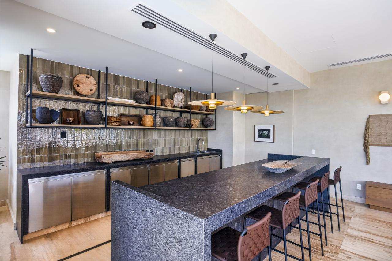 Clubhouse kitchen and long stone bar with pendant lighting