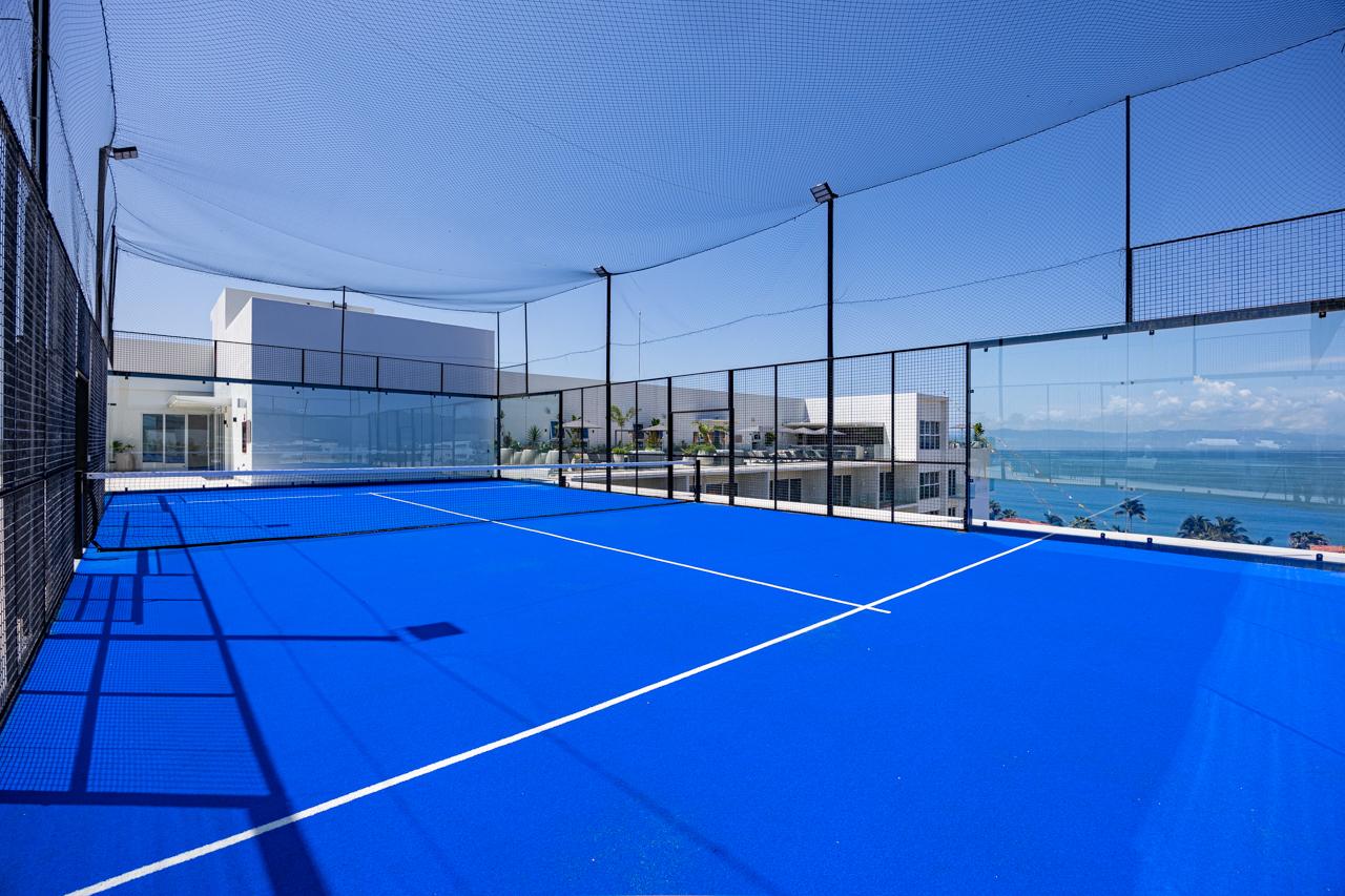 Inside the rooftop pickleball court looking toward the ocean