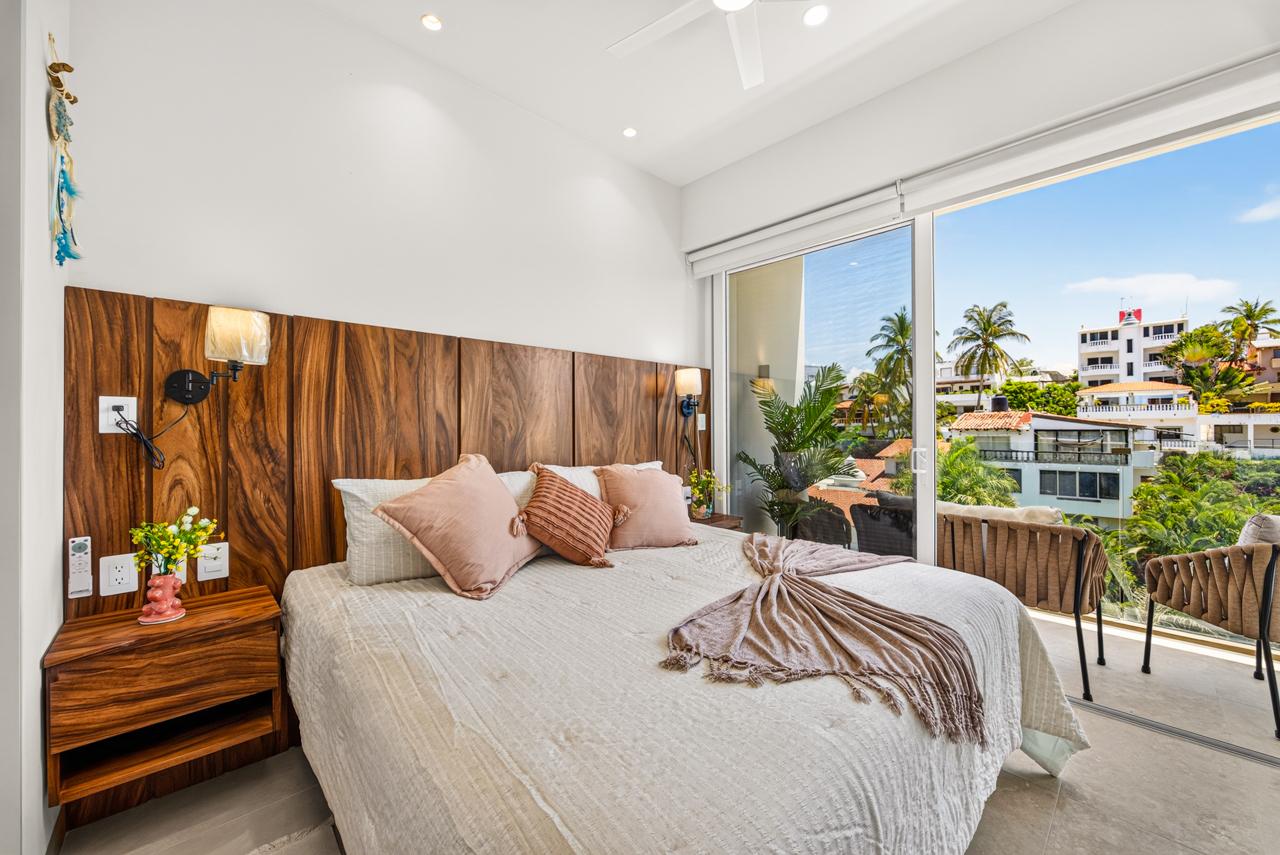 King bedroom at Casa Nayah with wood headboard and open balcony to palms