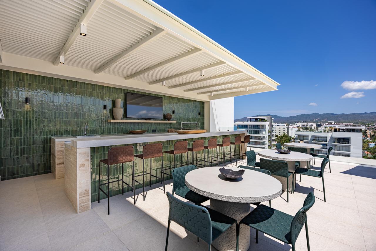 Rooftop dining area with emerald-tile bar and shaded pergola